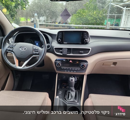 פנים רכב עם הגה ומערכת מולטימדיה